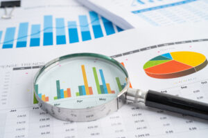 Magnifying glass on charts graphs paper. Financial development, Banking Account, Statistics, Investment Analytic research data economy, Stock exchange trading, Business office company meeting concept.