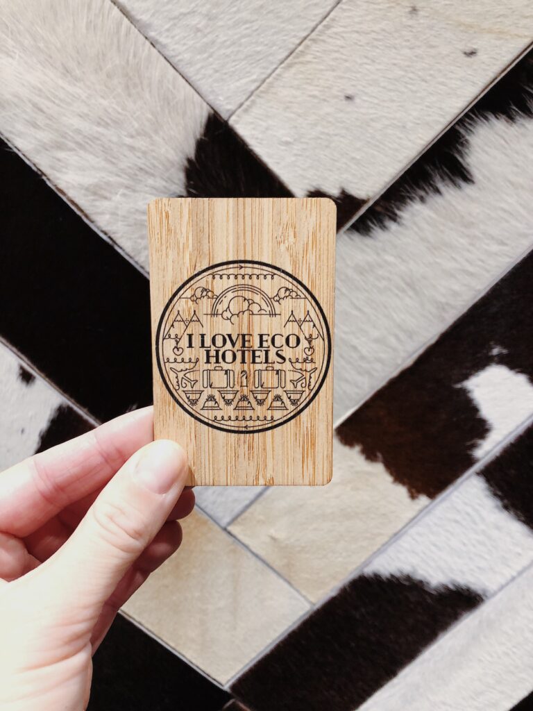 Hand holding eco wooden hotel room card