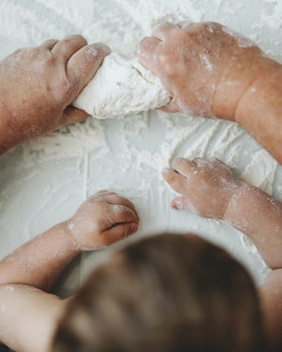 Grandmother teaching baby cooking home